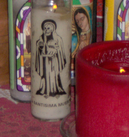 an image of a candles in front of several religious items