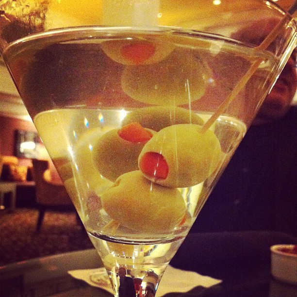 a martini glass with olives and cherries in it