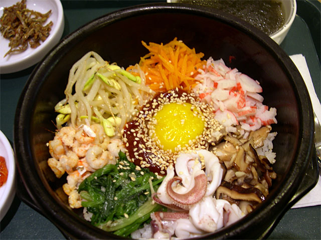 a tray filled with asian food and vegetables