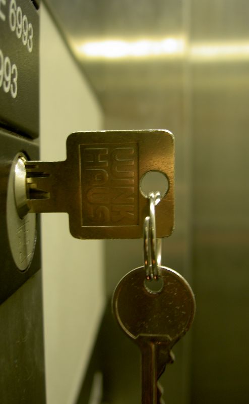 a gold key is hung from a security box