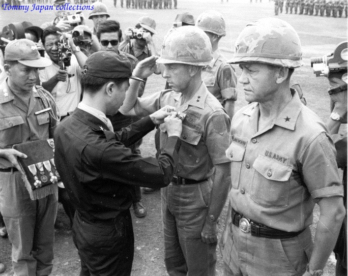 two uniformed officers pinning a medal around others