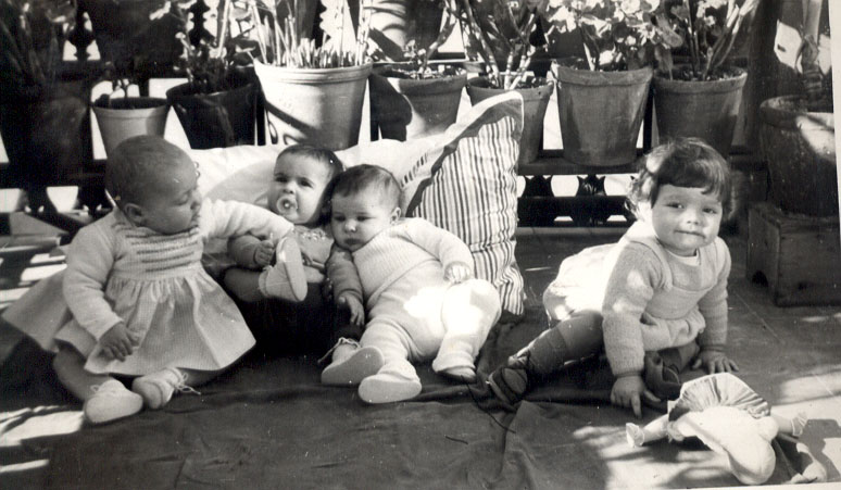 a group of baby s sitting around each other