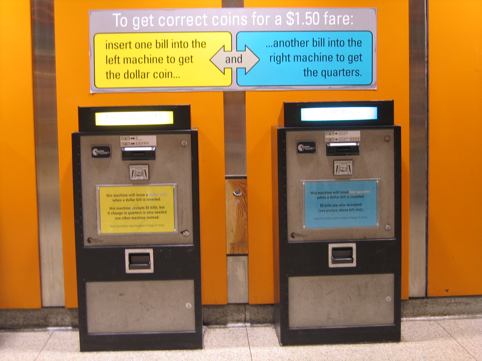 two parking meters in front of a sign