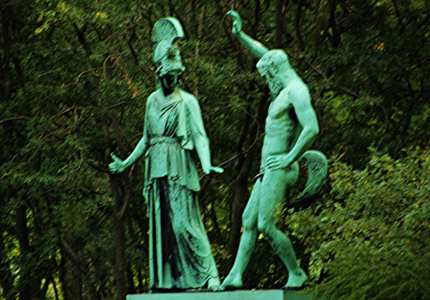 two green statues facing away from each other