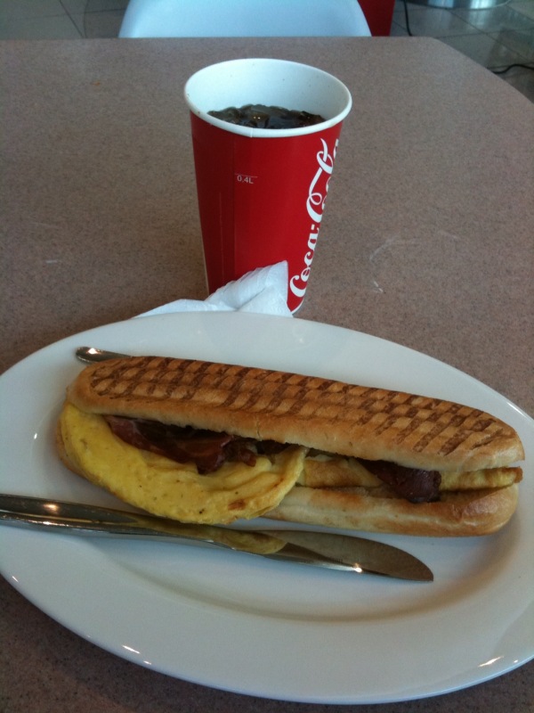 a sandwich sits on a plate with a fork next to it