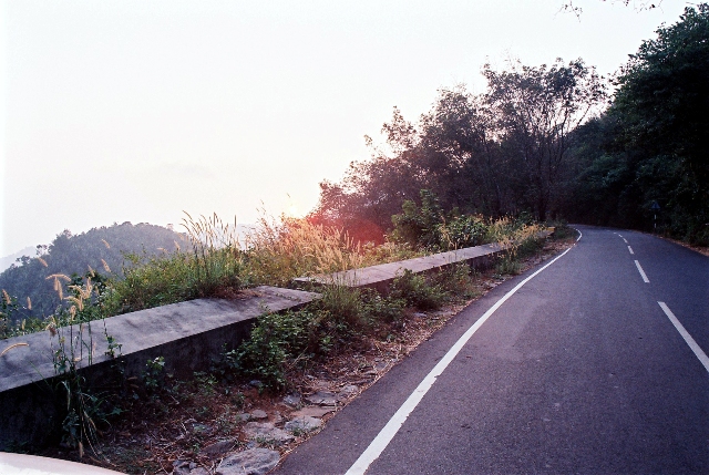 an empty road with a wooden barrier on the side