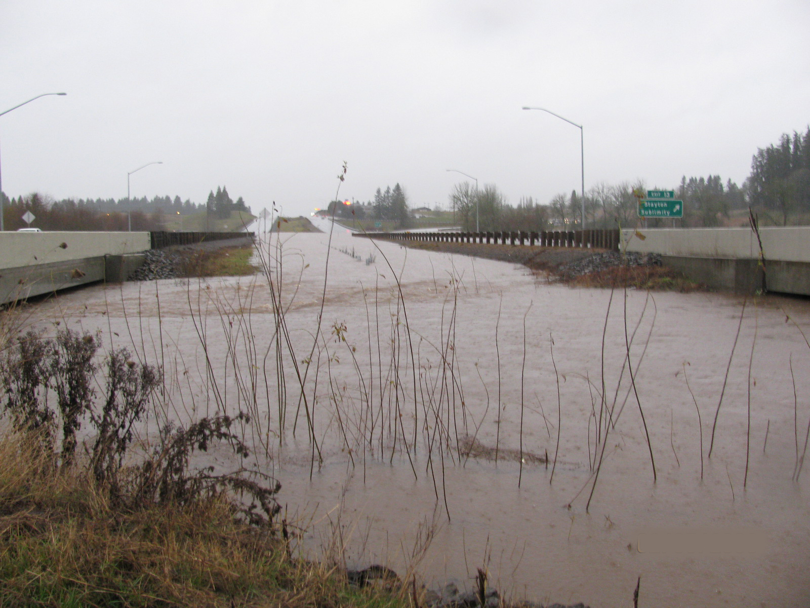 a flooded road in the country during a rain shower