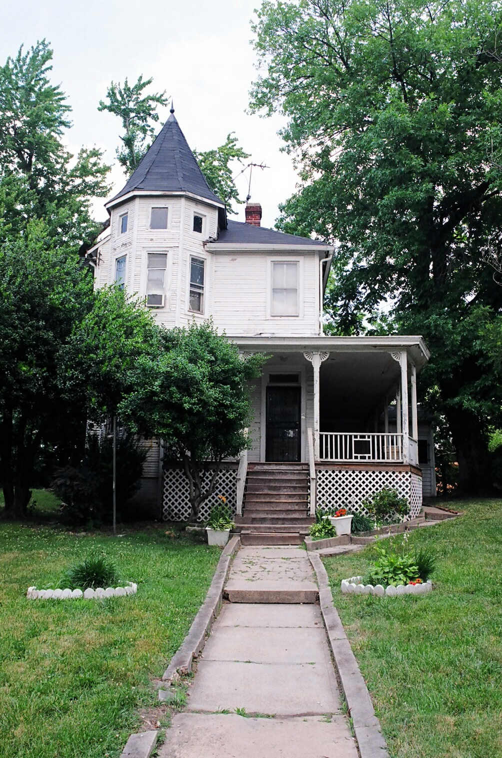 an old run down victorian style house with a front porch