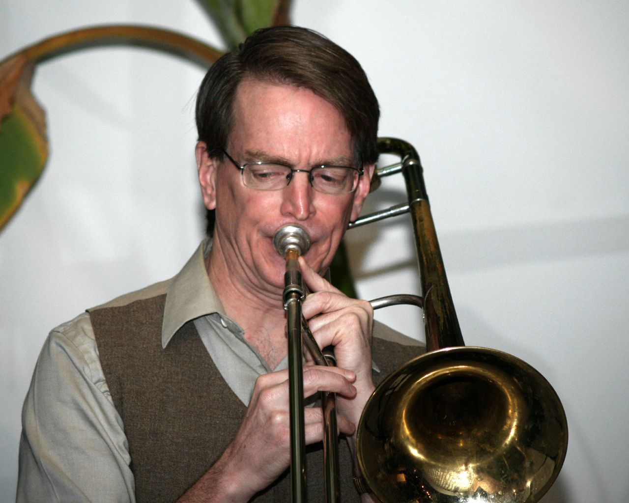 a man that is playing a trumpet in front of a microphone