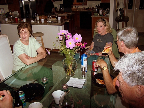 people sitting at a kitchen table eating and talking