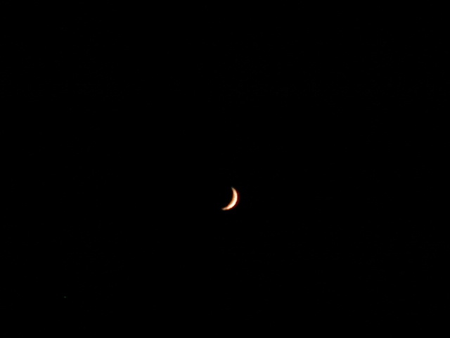 the moon is seen over the horizon with its shadow