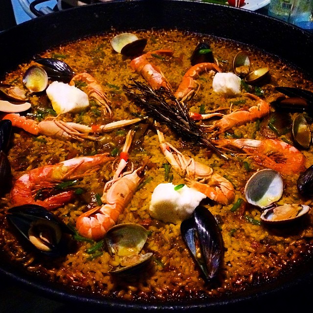 a black pan filled with shrimp and mussels