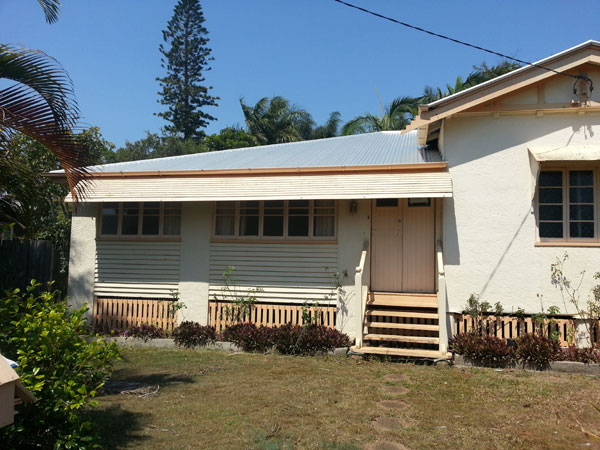 a white home in a quiet area with brown trim