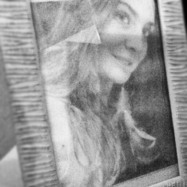 a blurry image of a woman is reflected in a picture frame