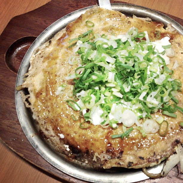 an up close picture of a baked dish with green onions
