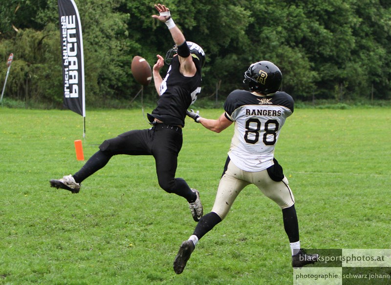 two men in uniform playing american football on the field