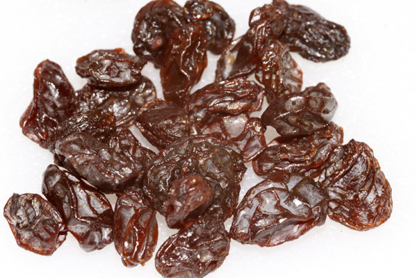 a pile of raisins on top of a white surface
