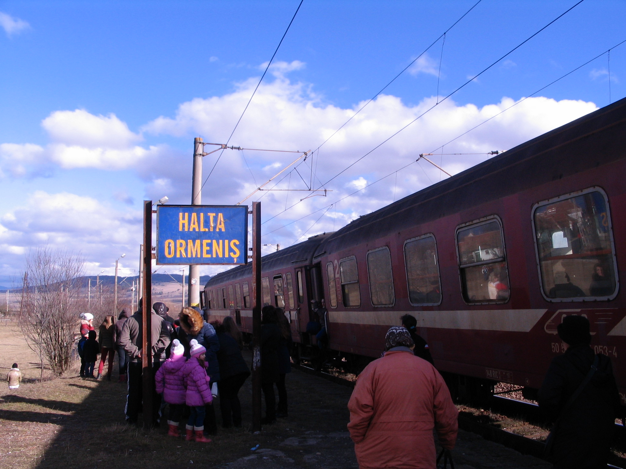 people standing in the dirt outside of a train station