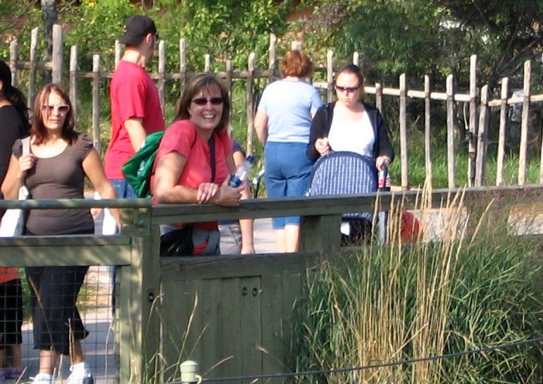 several people walking across the bridge to get on and off the boat