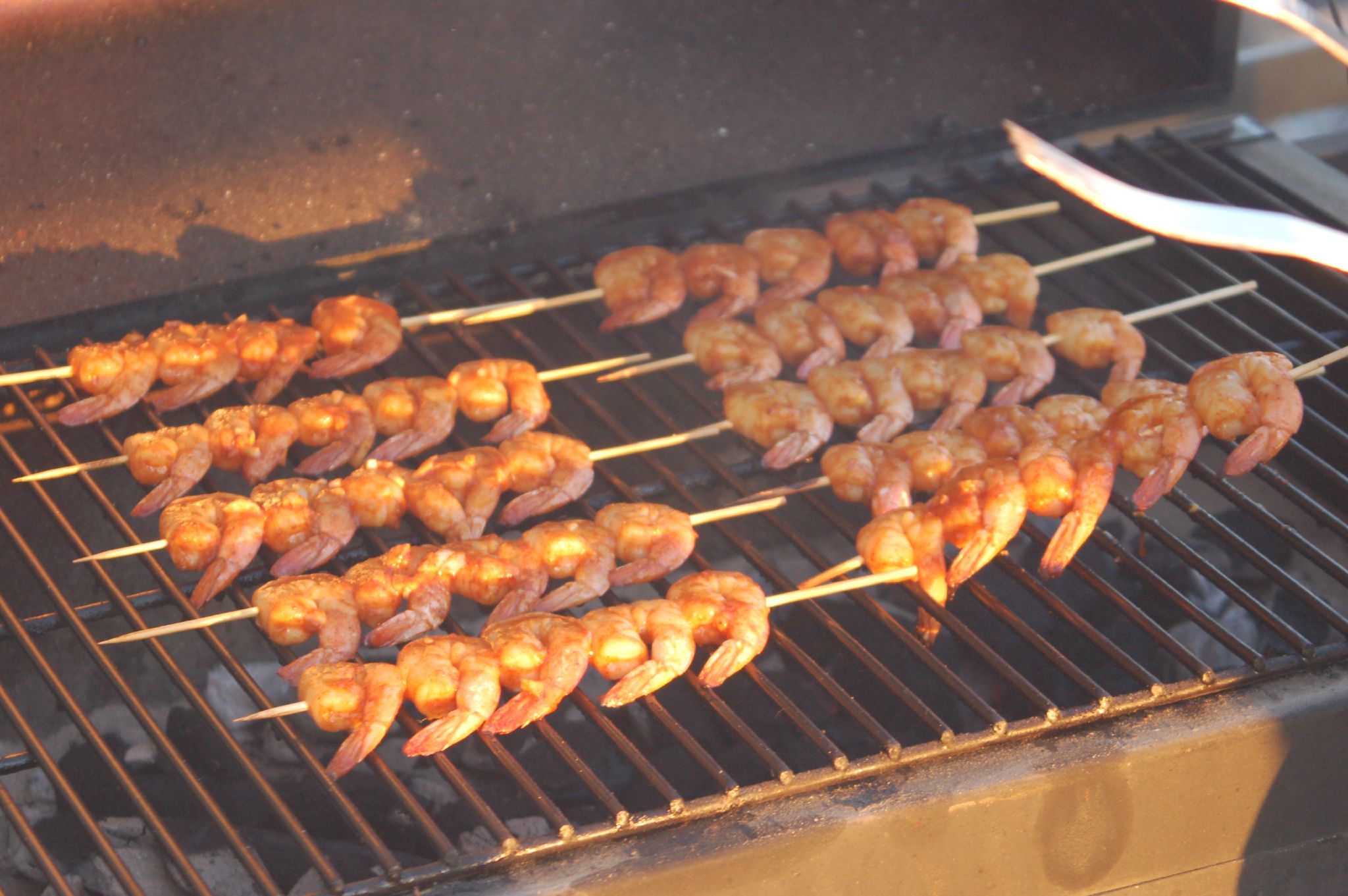 a large grill filled with shrimp on skewers