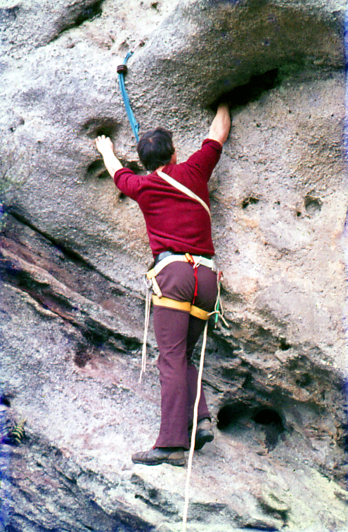 a man is rock climbing up a steep cliff