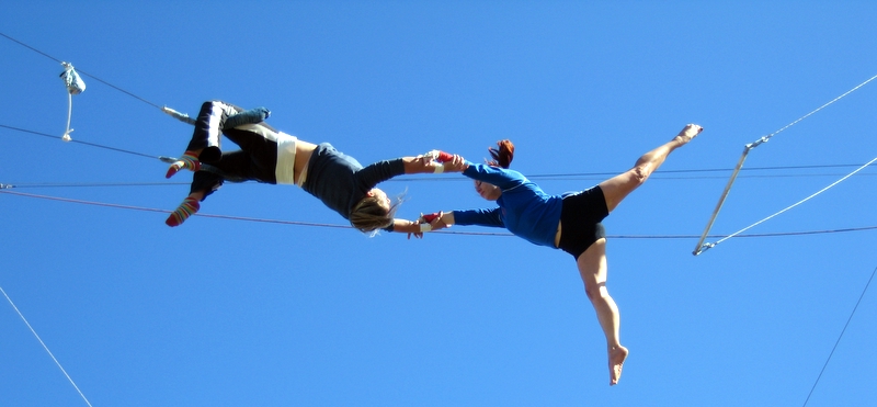 two performers in aerial pose during performance