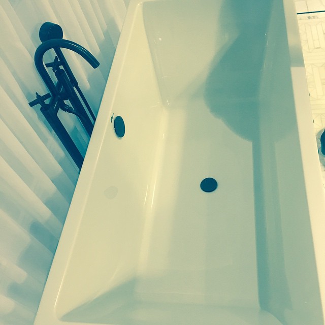 an empty bath tub next to a sink in a bathroom