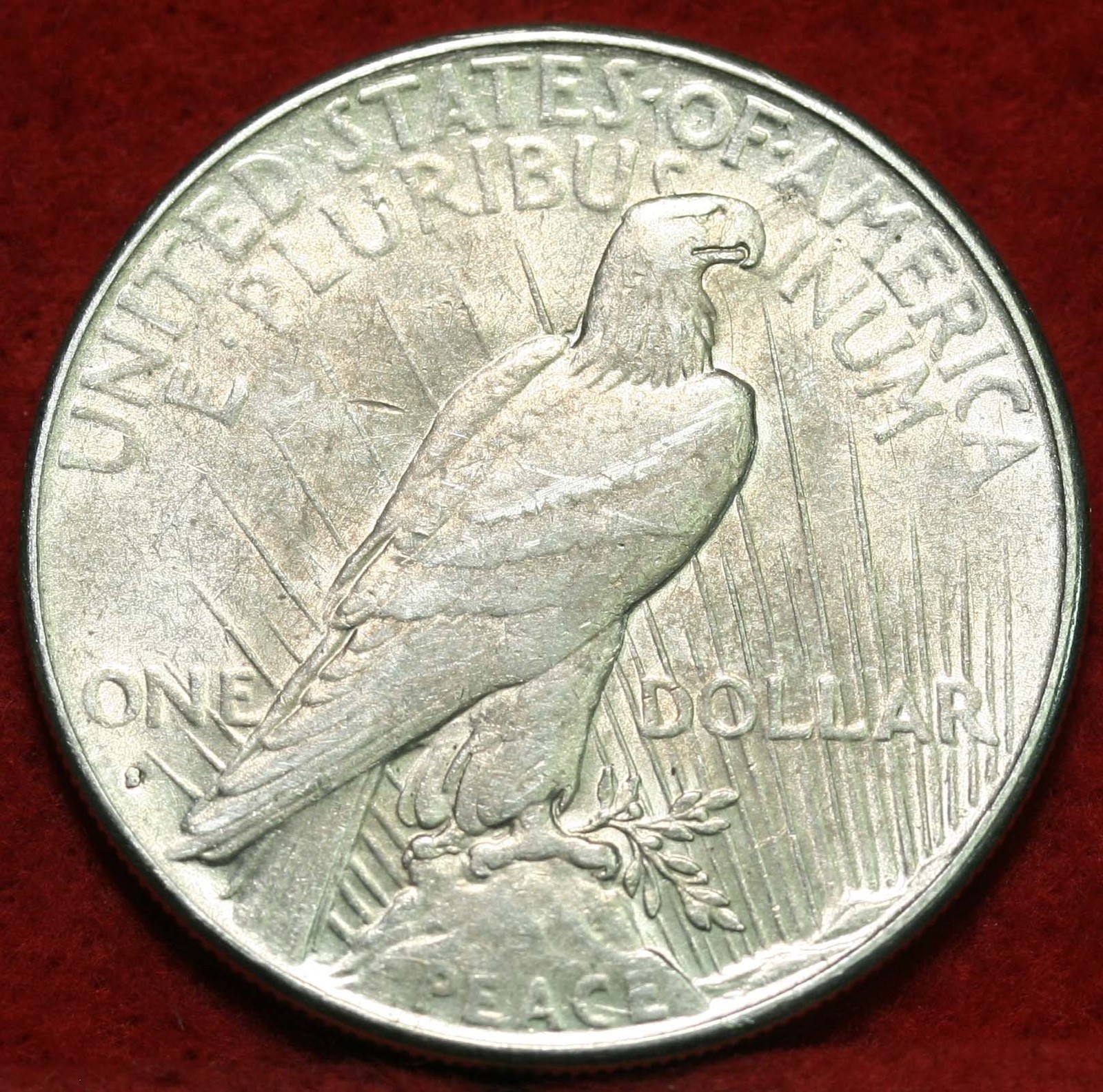 a large silver penny sits on a red surface