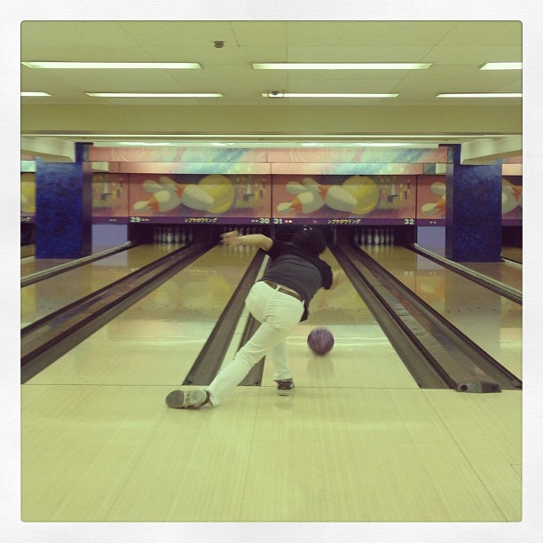 a man bending over to pick up a bowling ball