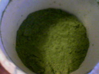a close up of a blender containing green powder