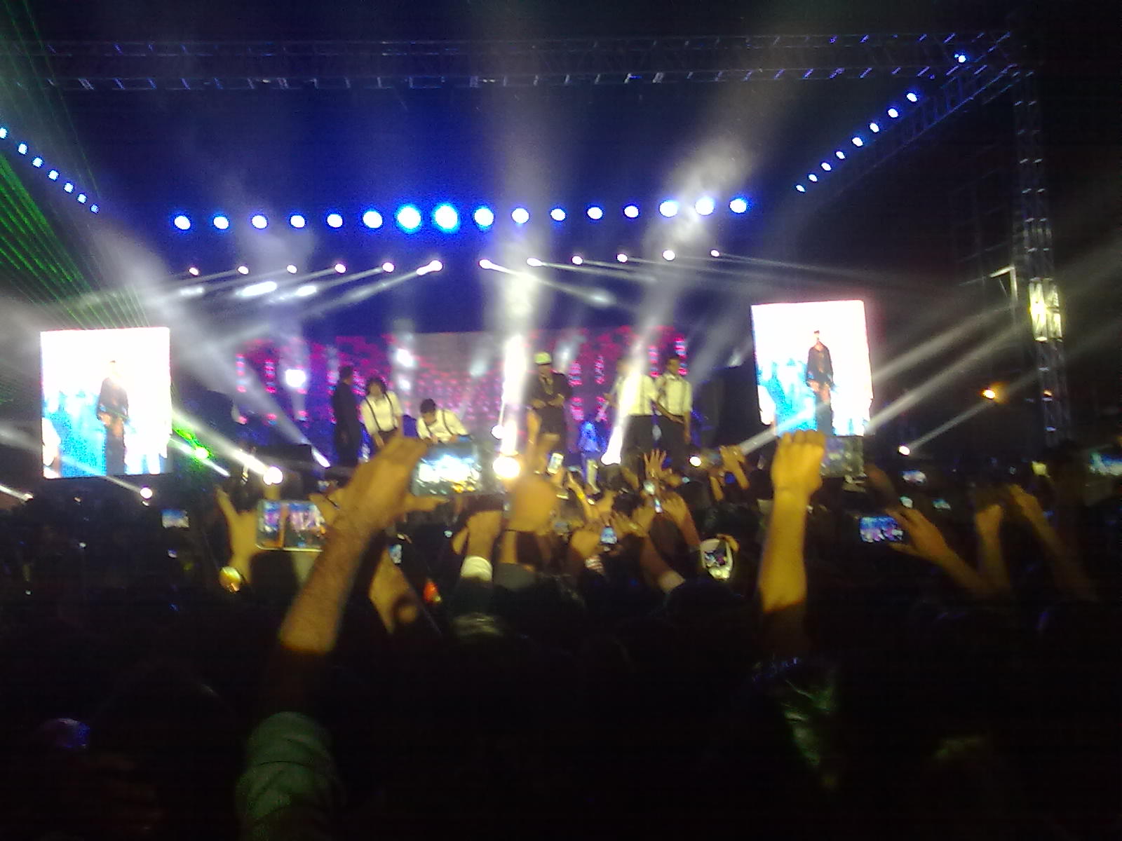 a crowd at a concert waving their hands