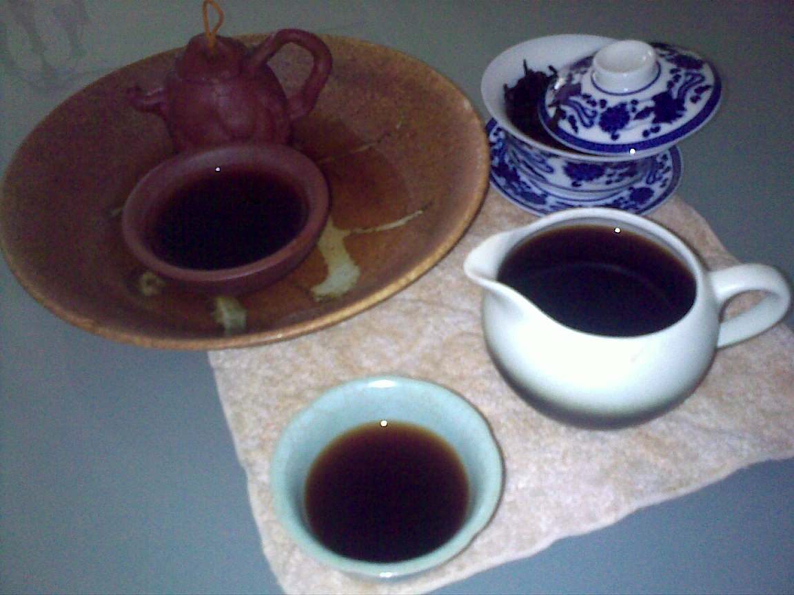 a tray with coffee cups and tea pot next to each other