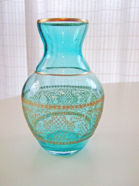 a blue glass vase sitting on a white table