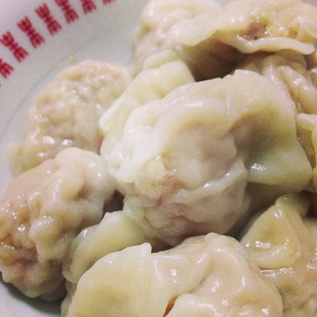 a plate full of dumplings that are covered in sauce