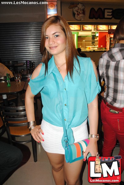 a woman in a blue shirt is posing for the camera
