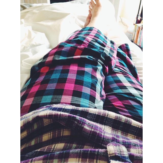 a person laying on a bed with colorful plaid clothing