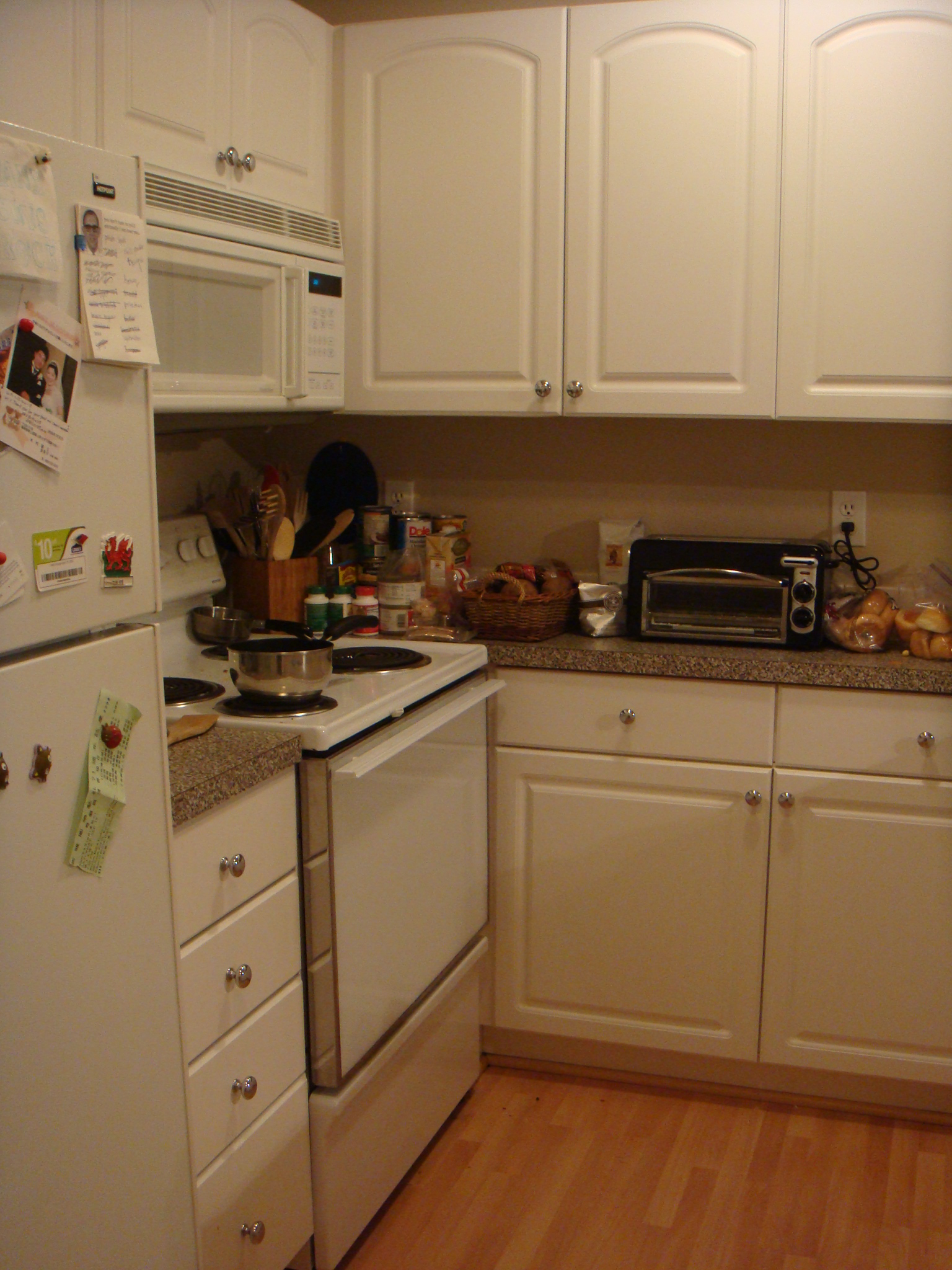 a kitchen has all white cabinets, wood floors, and wood flooring