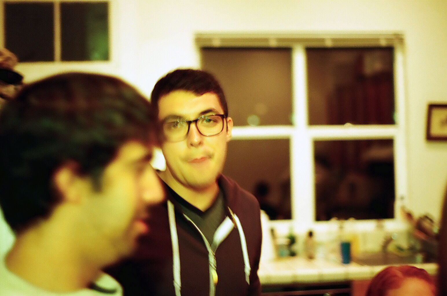 a young man in glasses looks to the side