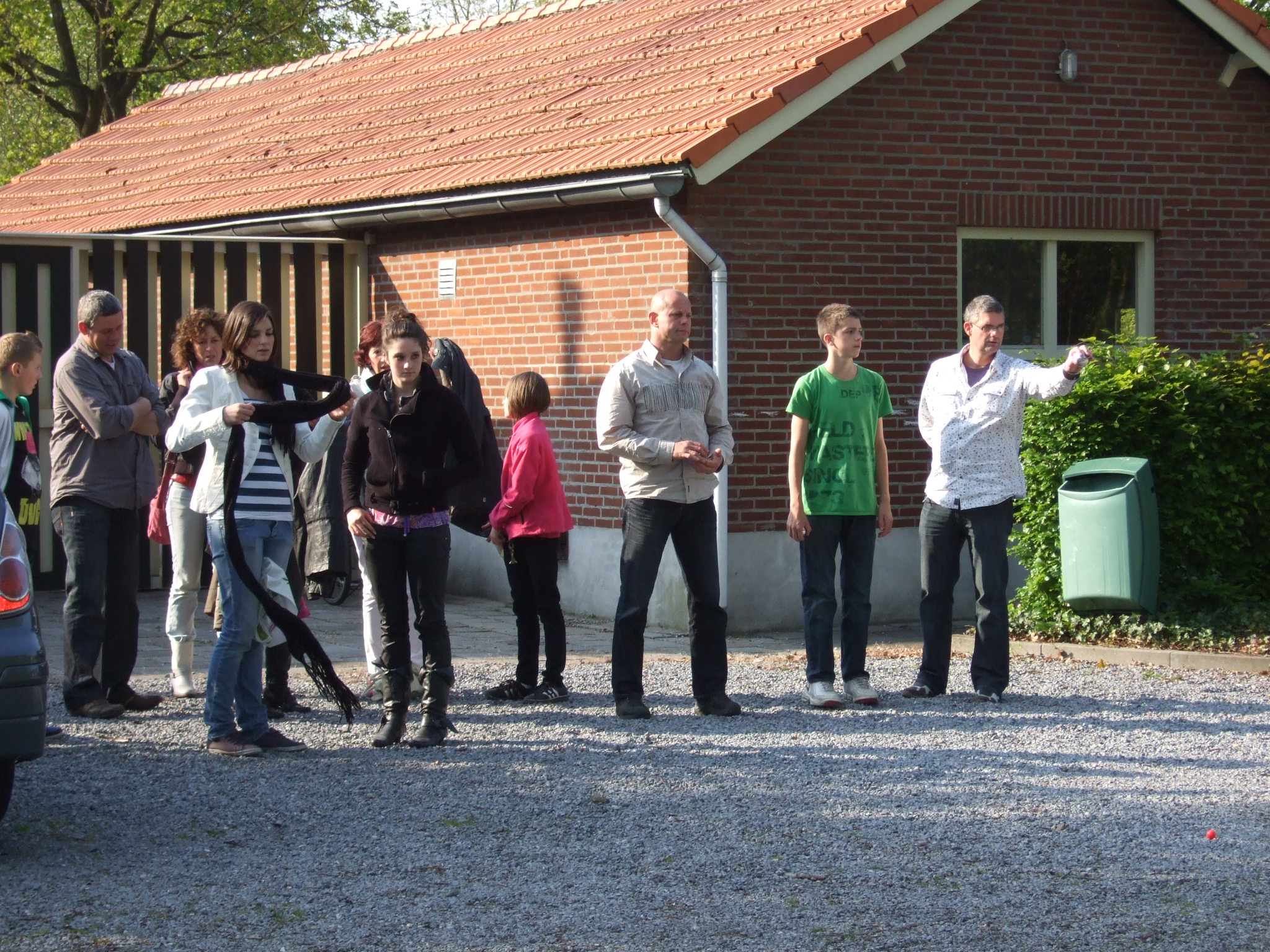 several people are standing in front of a small house