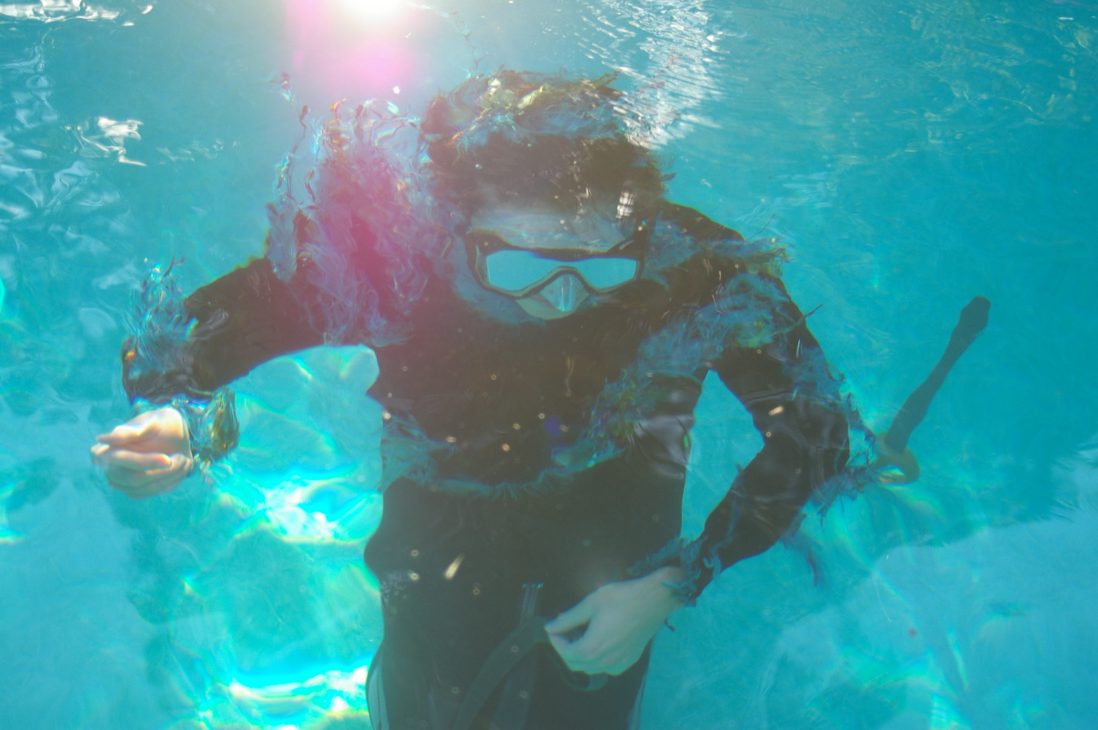 a person in a black scuba suit in a pool