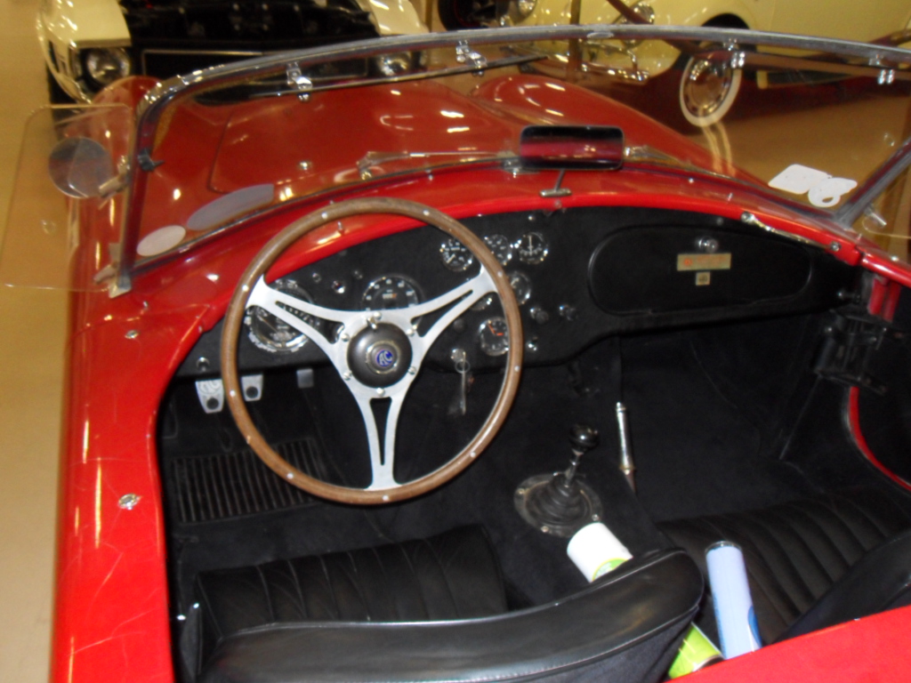 a red sports car with wood steering and steering wheel