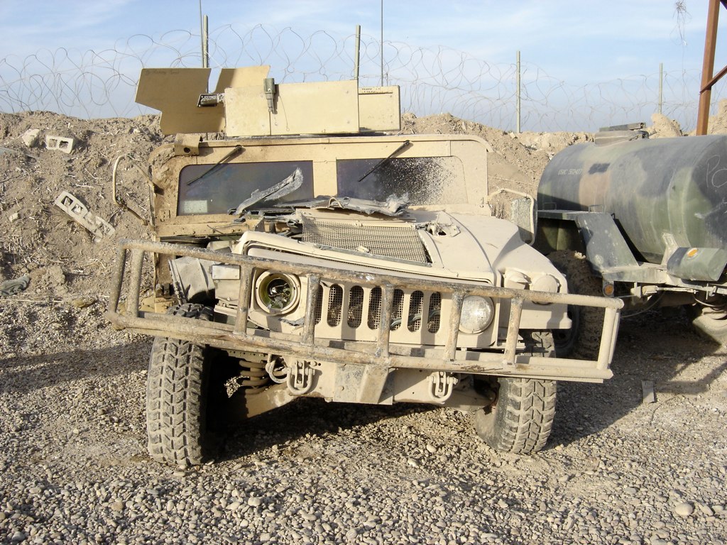 two military vehicles are sitting on the side of the road