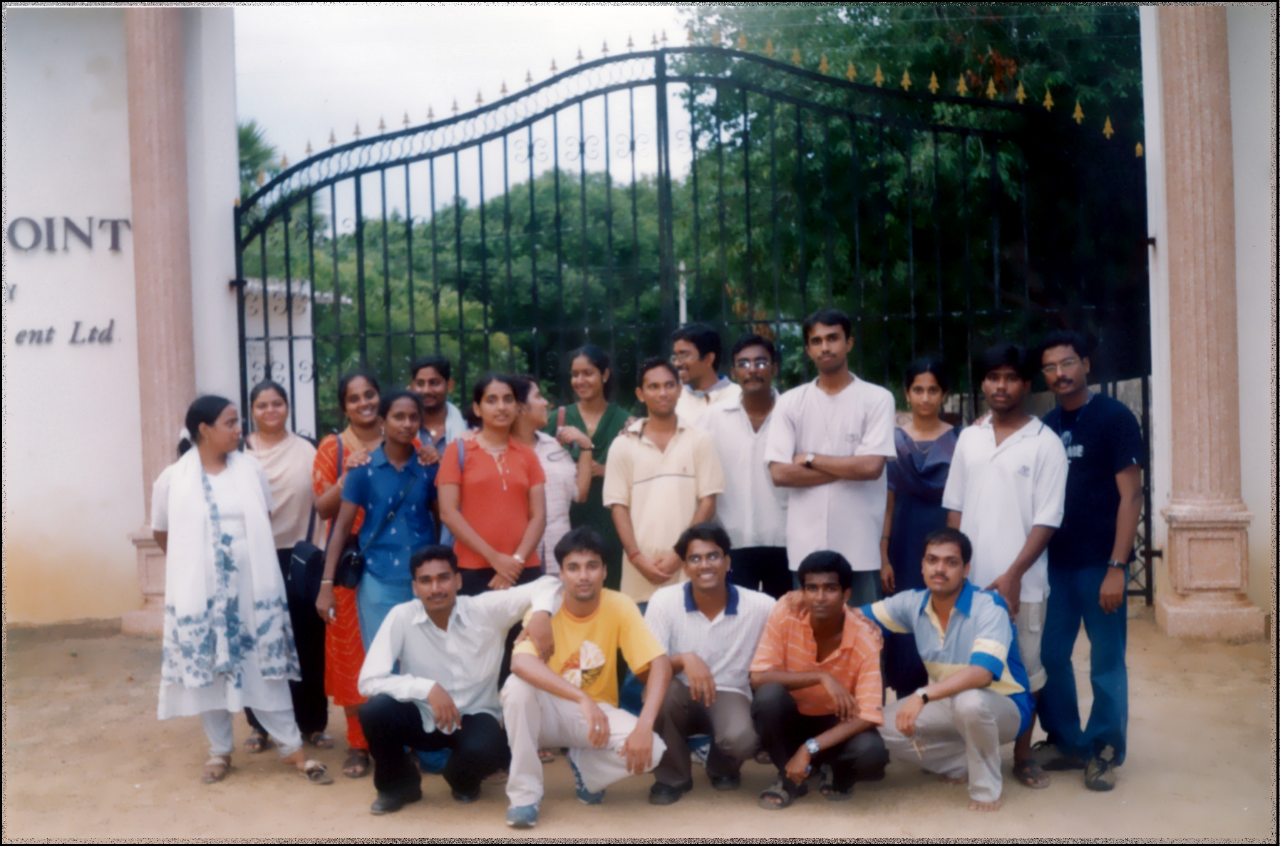 a group of people are posing for a picture in front of a gate