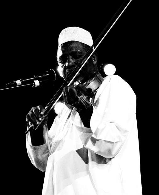 a man playing a violin on stage in black and white
