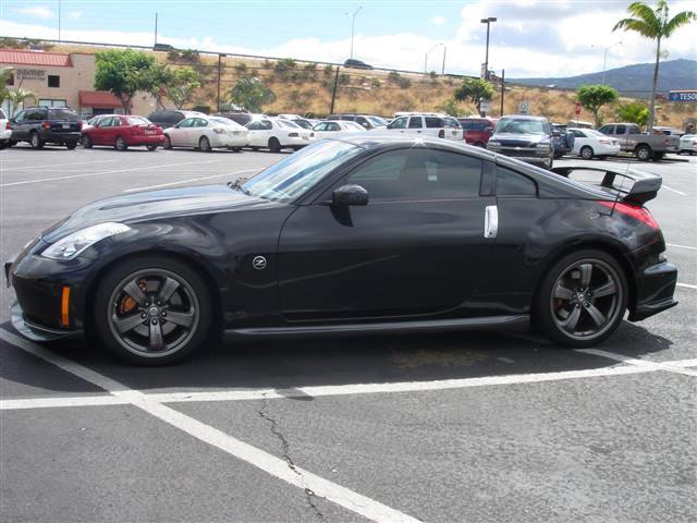 a black sports car is parked in the middle of a parking lot
