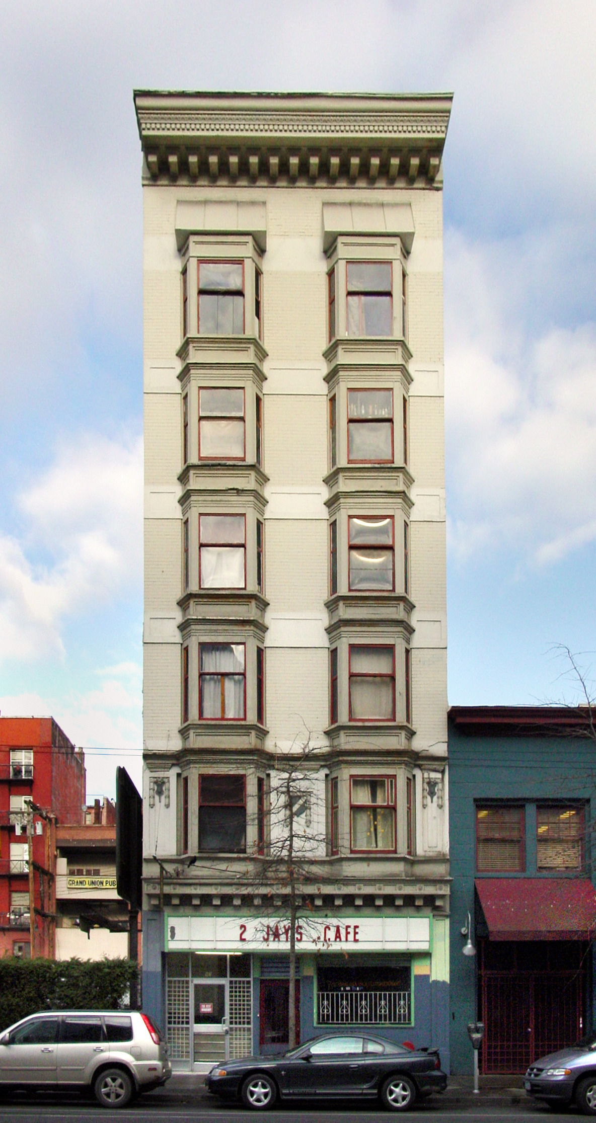 a building sits next to a tall white one