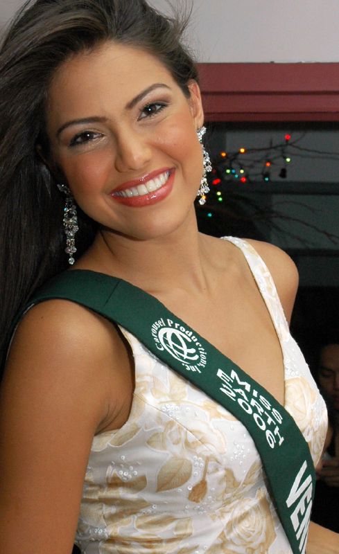 a young woman wearing a sash smiling at the camera