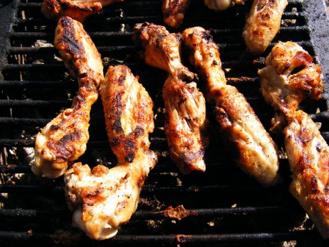 chicken wings, carrots and more are being prepared on a grill