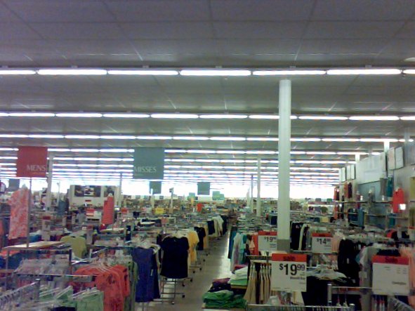 a store filled with lots of clothing next to a ceiling