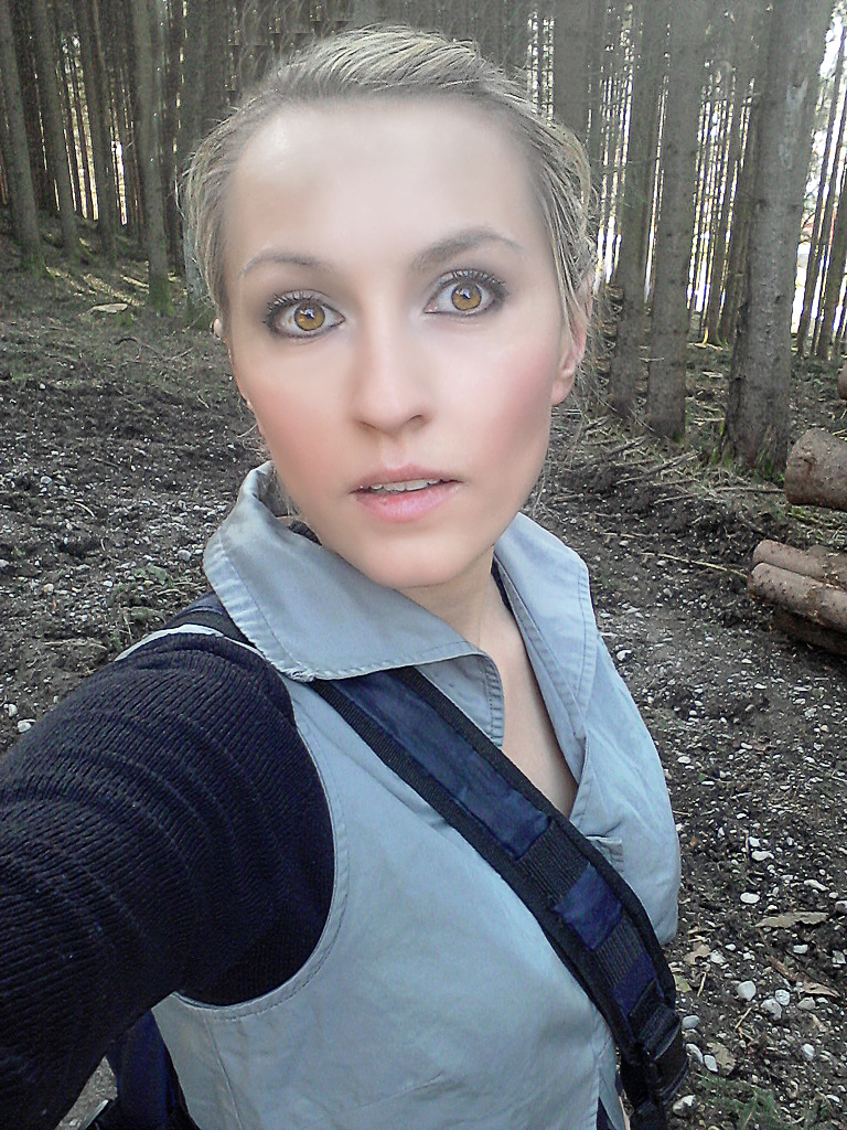 a female wearing a backpack is in the woods